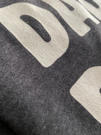 Load image into Gallery viewer, Close-up of soft fabric and print detail on the Dada. Daddy. Dad. Bruh. Everyday Tee in dark grey heather