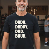 Load image into Gallery viewer, Dad wearing black Dada Daddy Dad Bruh tee in garage, teenager on phone in background, funny dad shirt for Father's Day