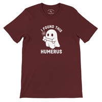 Load image into Gallery viewer, I Found This Humerus Everyday Tee in maroon, flat lay showing ghost with bone graphic and collar print