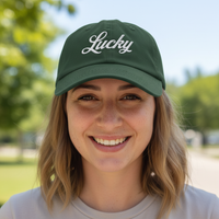 Load image into Gallery viewer, Person wearing a green cap with 'Lucky' text outdoors